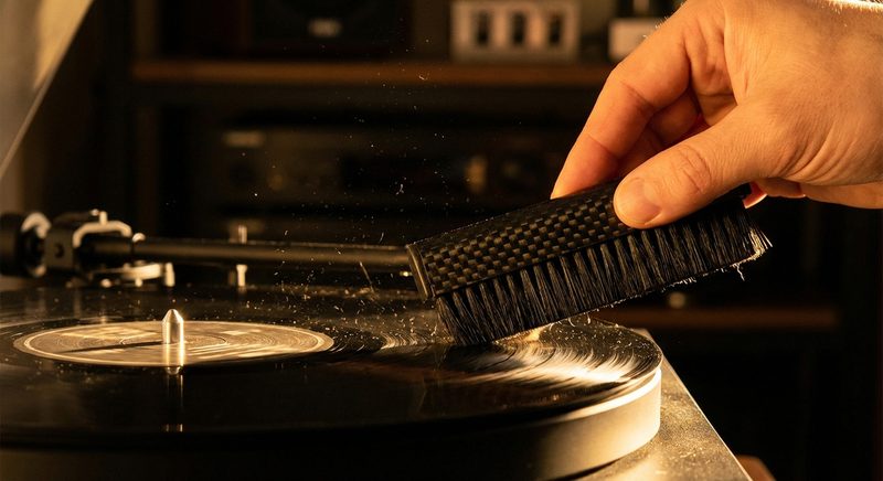 Carbonbuerste reinigt Schallplatte auf Plattenteller